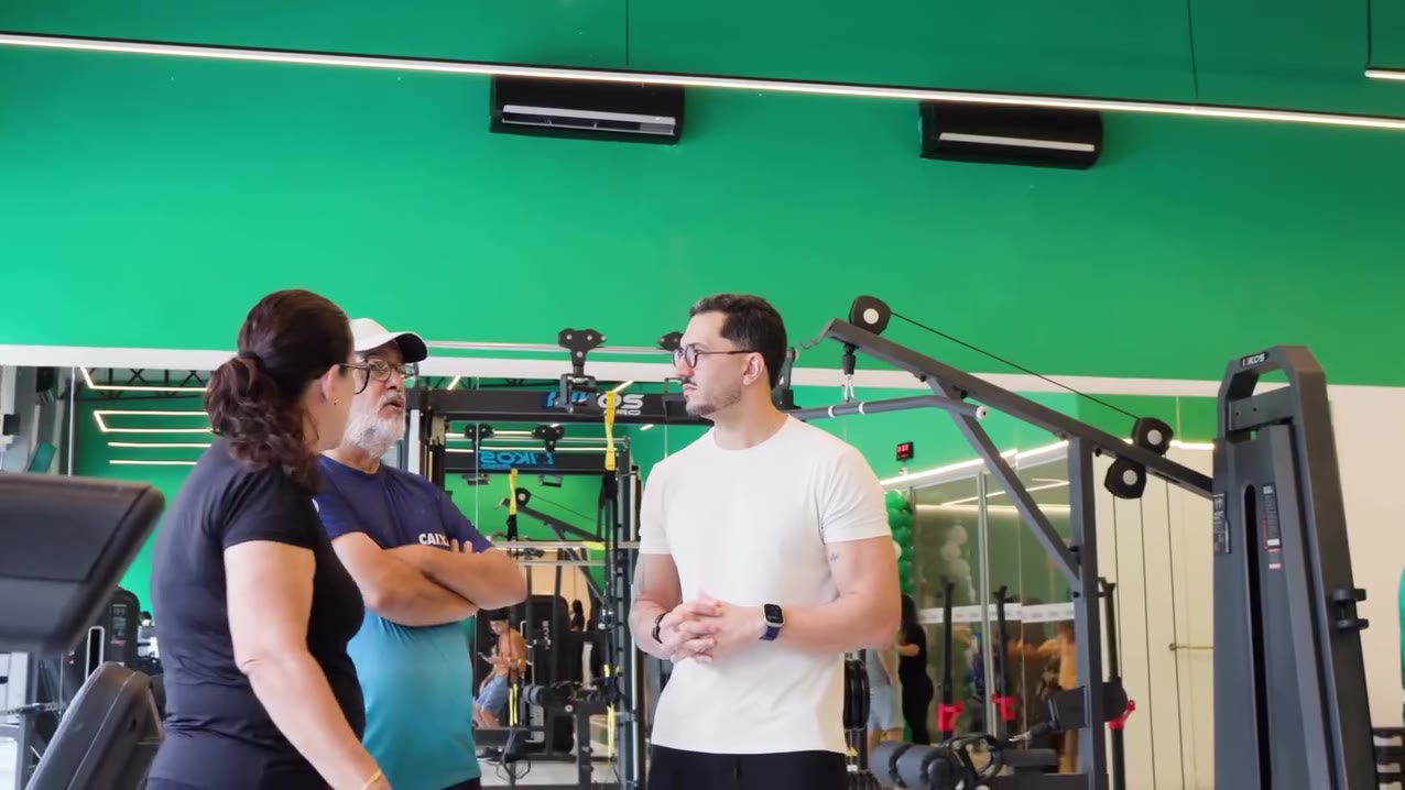 Professor conversando com alunos na sala de musculação